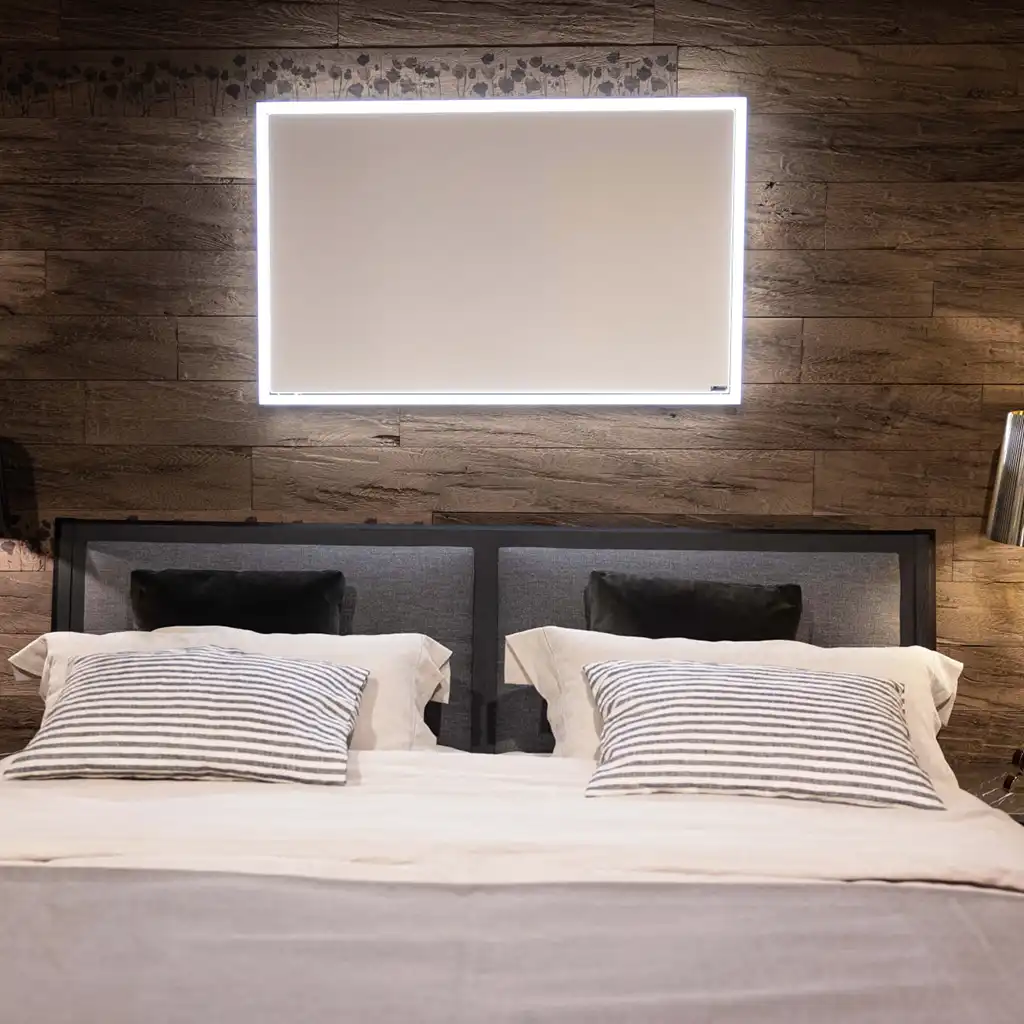 Ein modernes Schlafzimmer mit einem Doppelbett, gestreiften Kissen und einem beleuchteten Wandpaneel im Hintergrund.